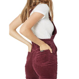 Person wearing maroon corduroy overalls on a white background