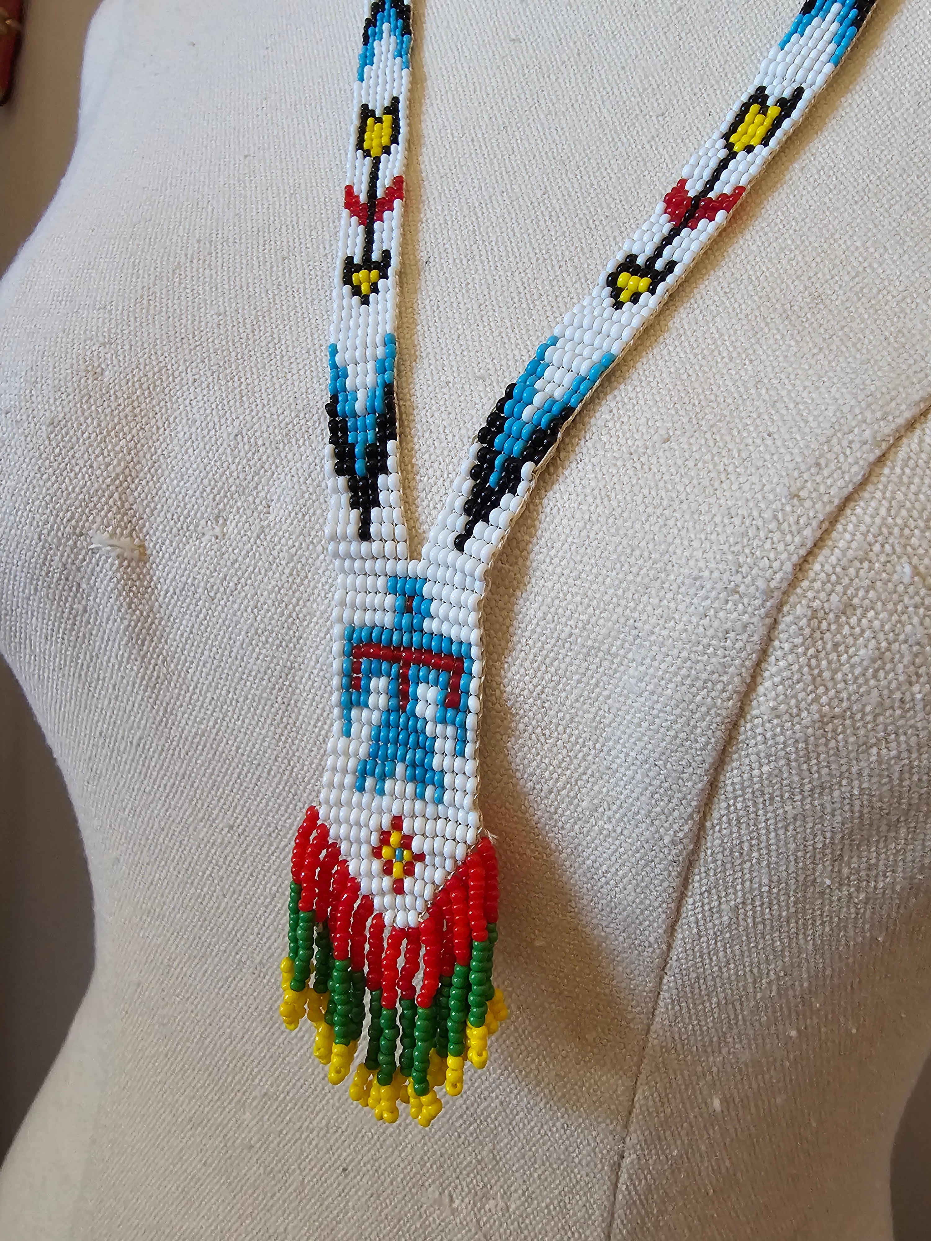 Close-up of a beaded necklace with colorful patterns on a beige fabric background