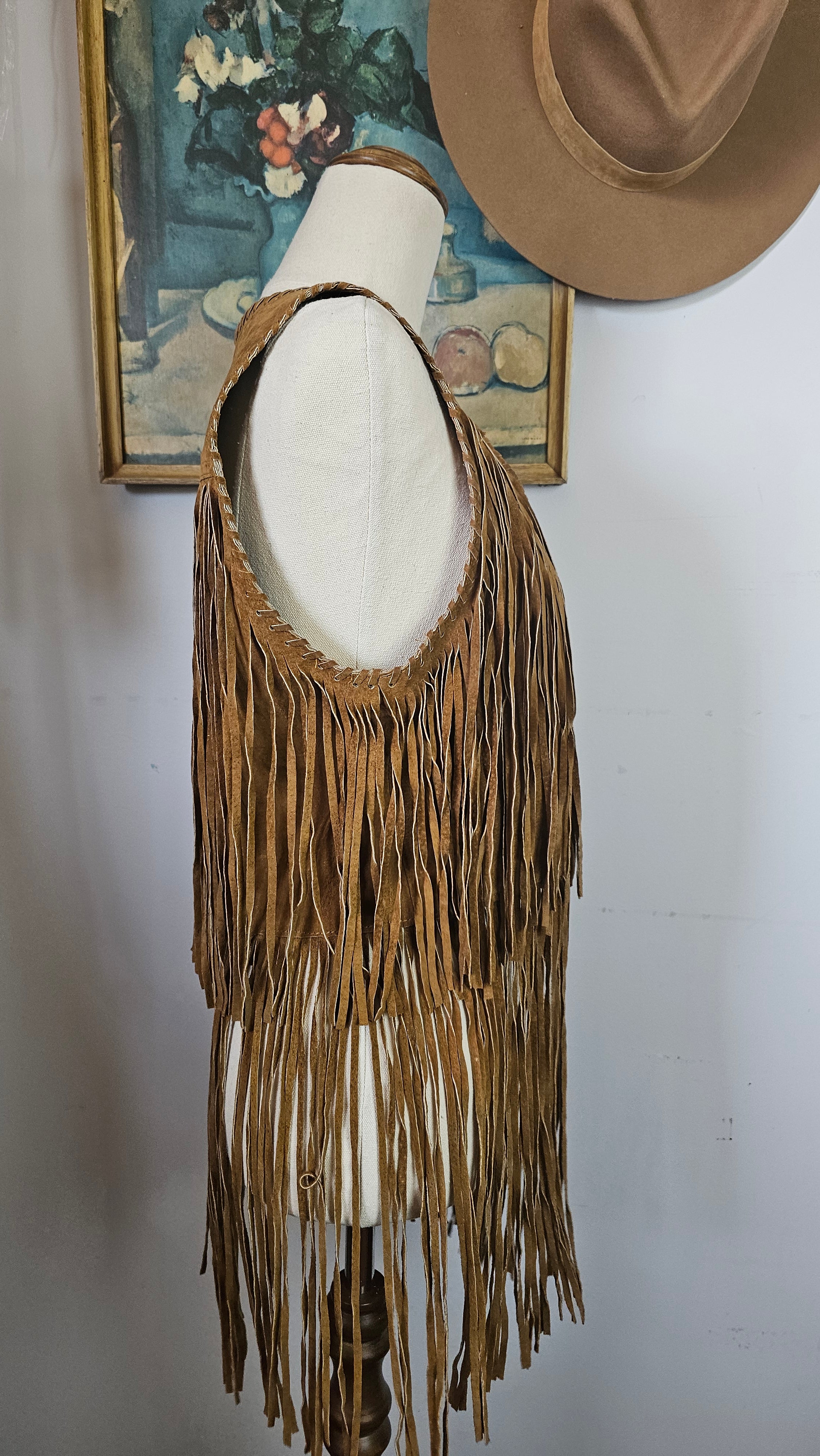 Brown hat with a decorative feather on a white background