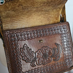 Brown leather wallet with floral embossing on a white background