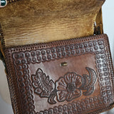 Brown leather wallet with floral embossing on a white background