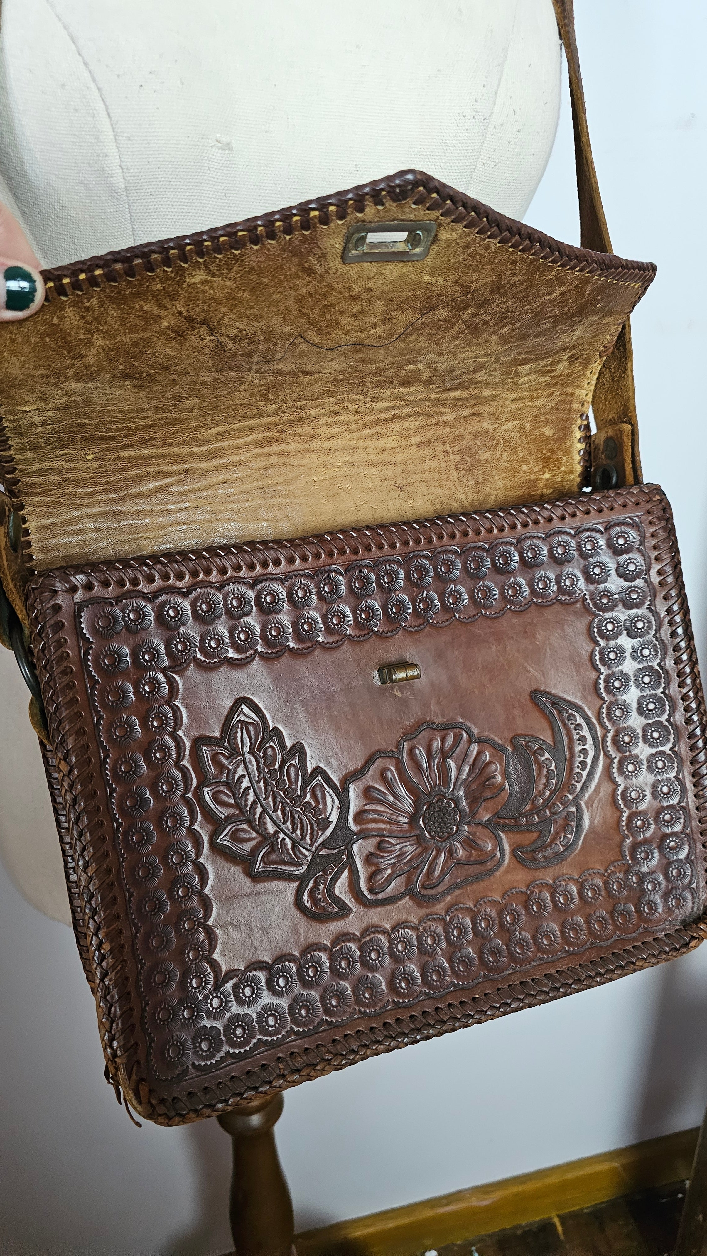Brown leather wallet with floral embossing on a white background