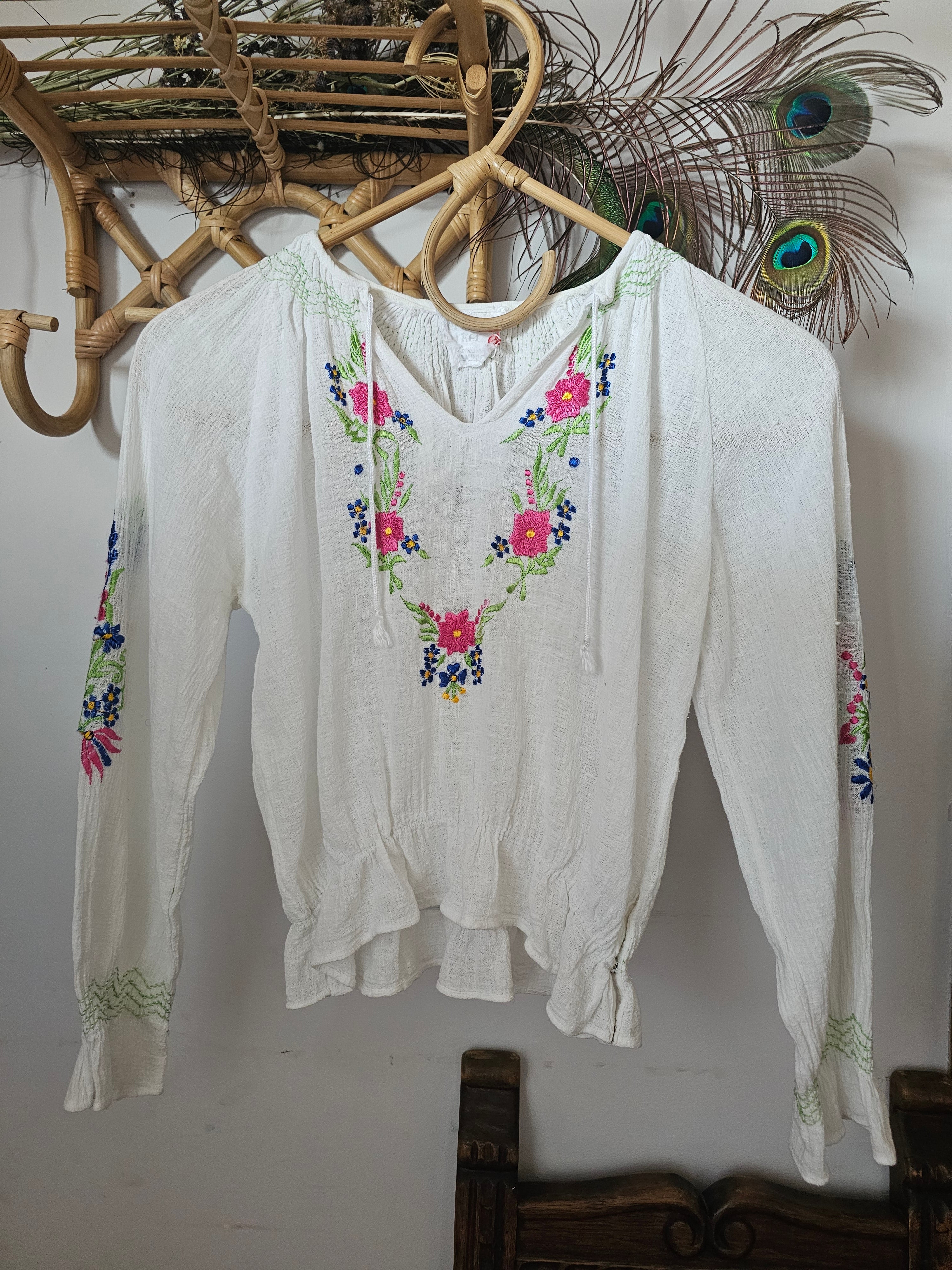 White blouse with floral embroidery on a white background