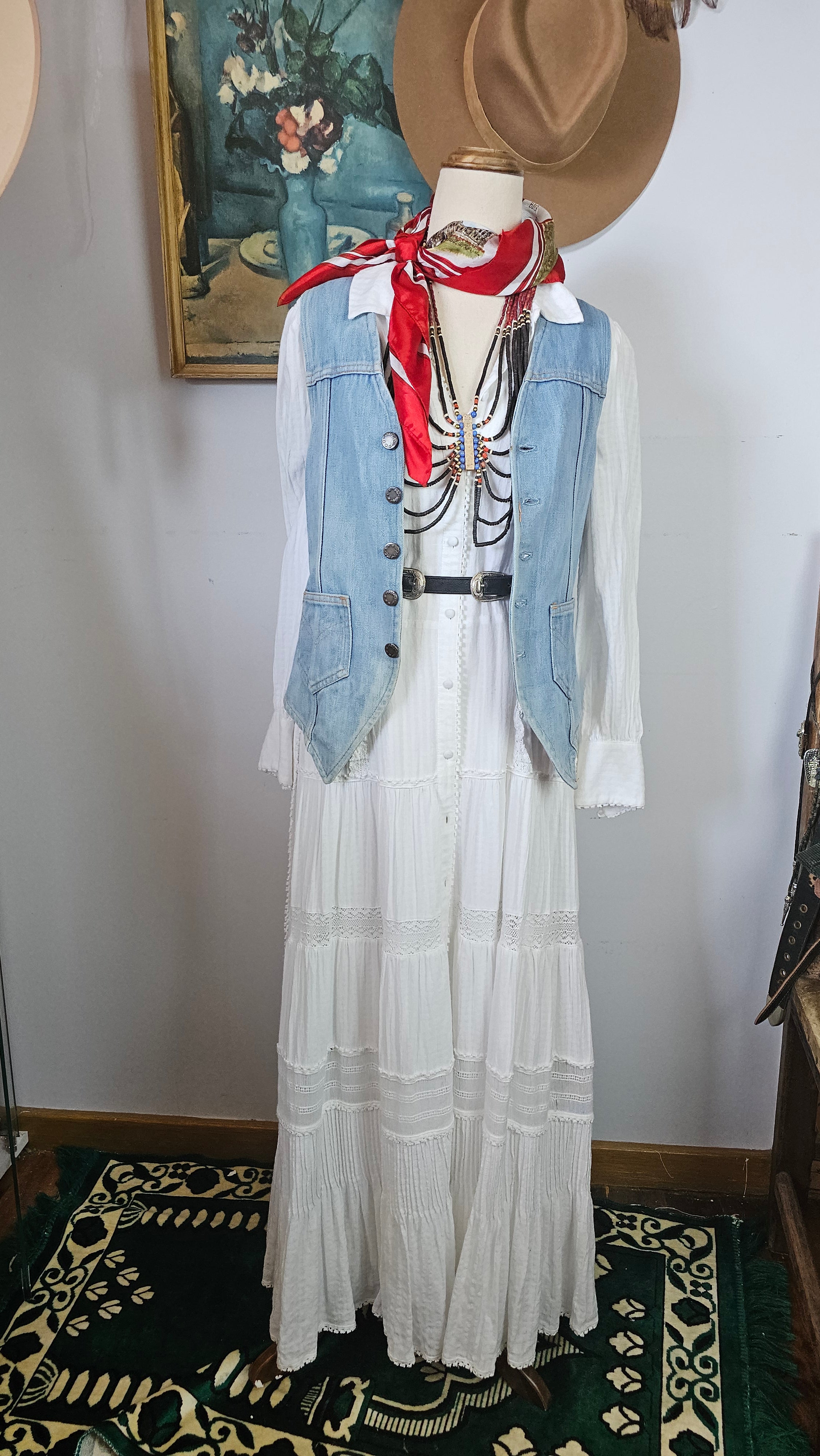 Mannequin wearing a denim jacket with a white shirt and red accents, standing against a plain background.