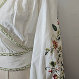White garment with floral embroidery on a white background