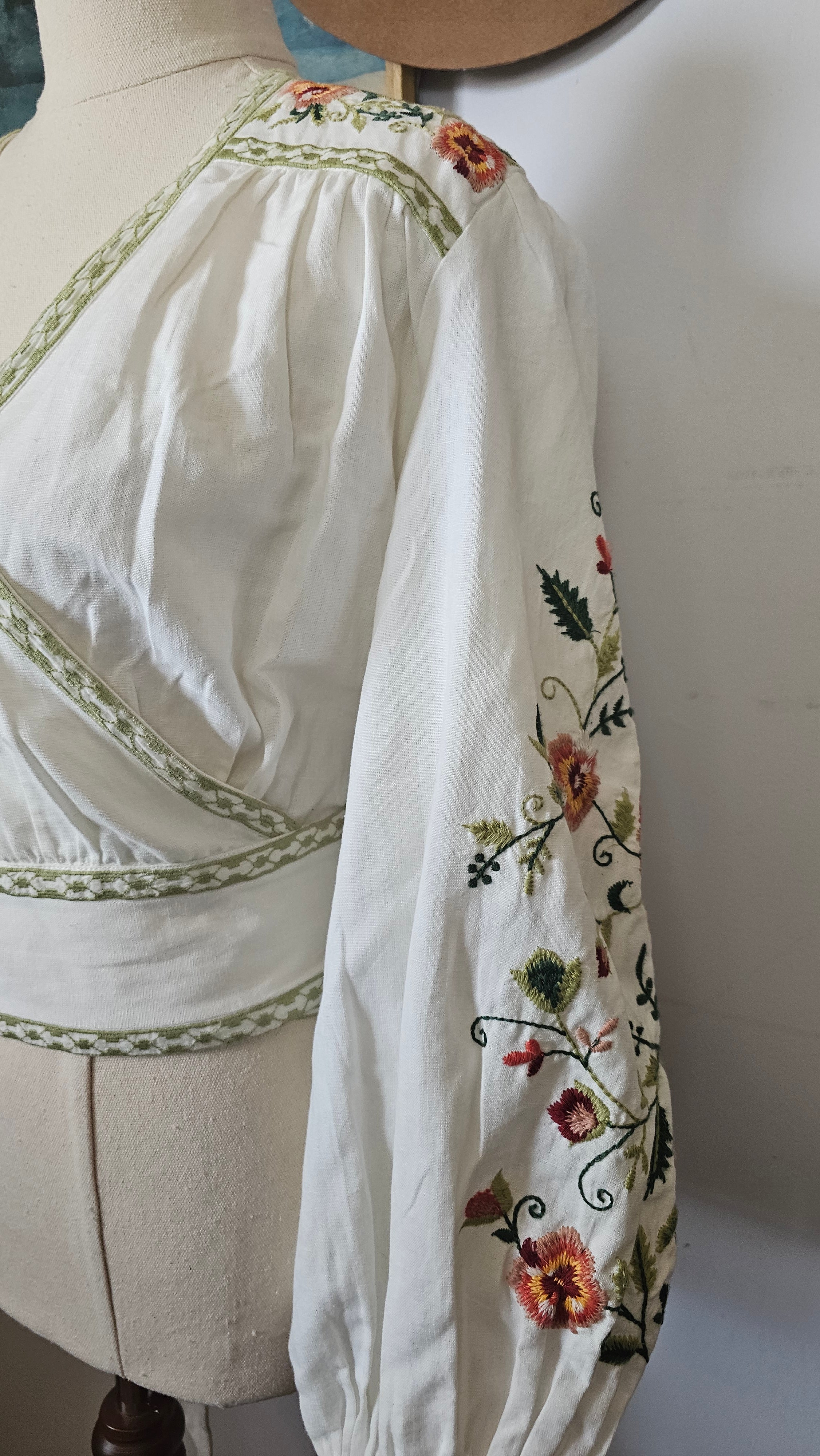 White garment with floral embroidery on a white background