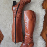 Brown knee-high boots on a fluffy white rug