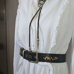 White lace garment with a black strap on a white surface