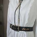 White lace garment with a black strap on a white surface