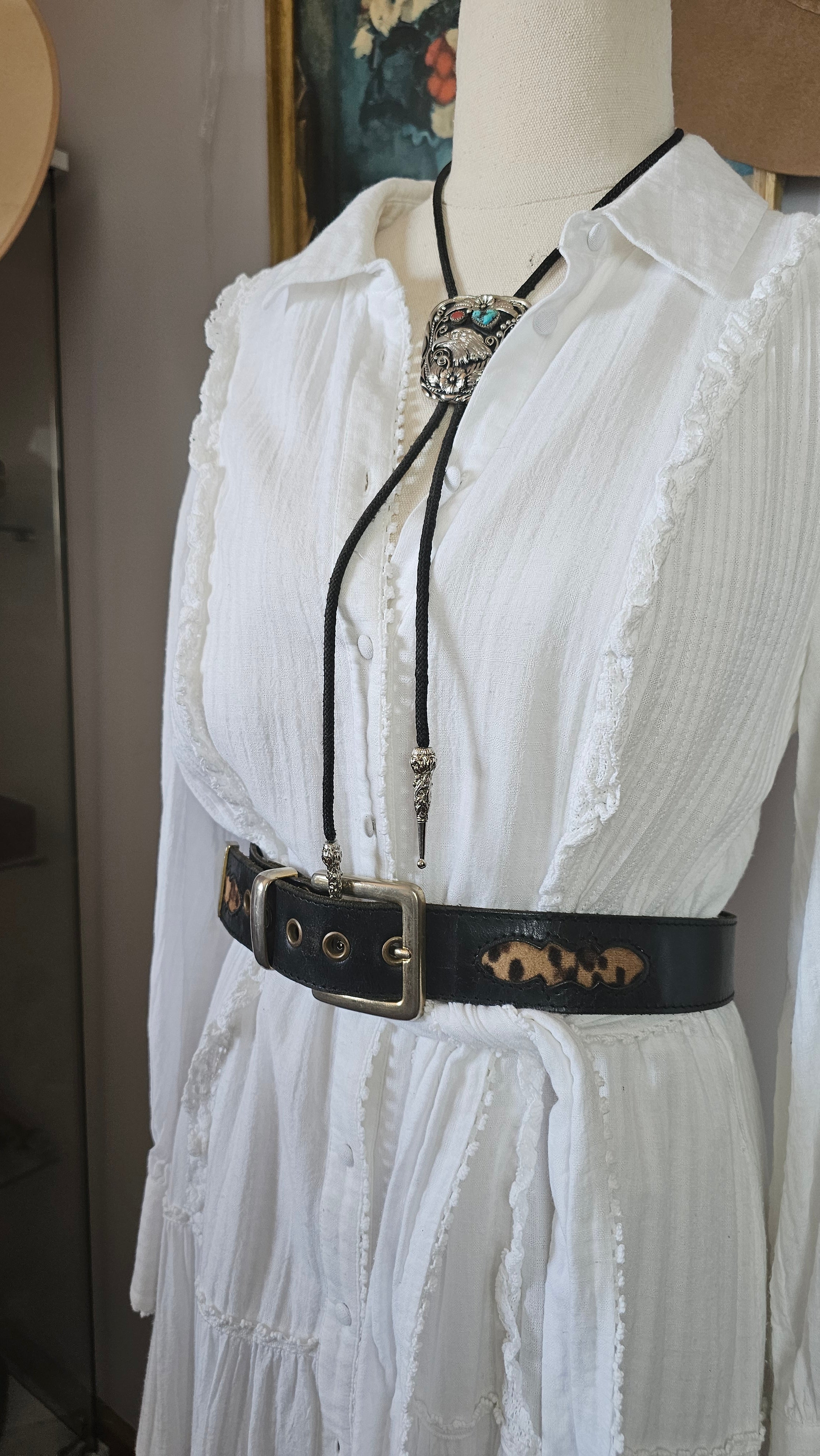 White lace garment with a black strap on a white surface