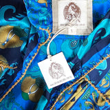 Close-up of a blue patterned fabric with gold accents and a visible brand tag.