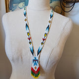 Mannequin head with a colorful beaded headband on a neutral background