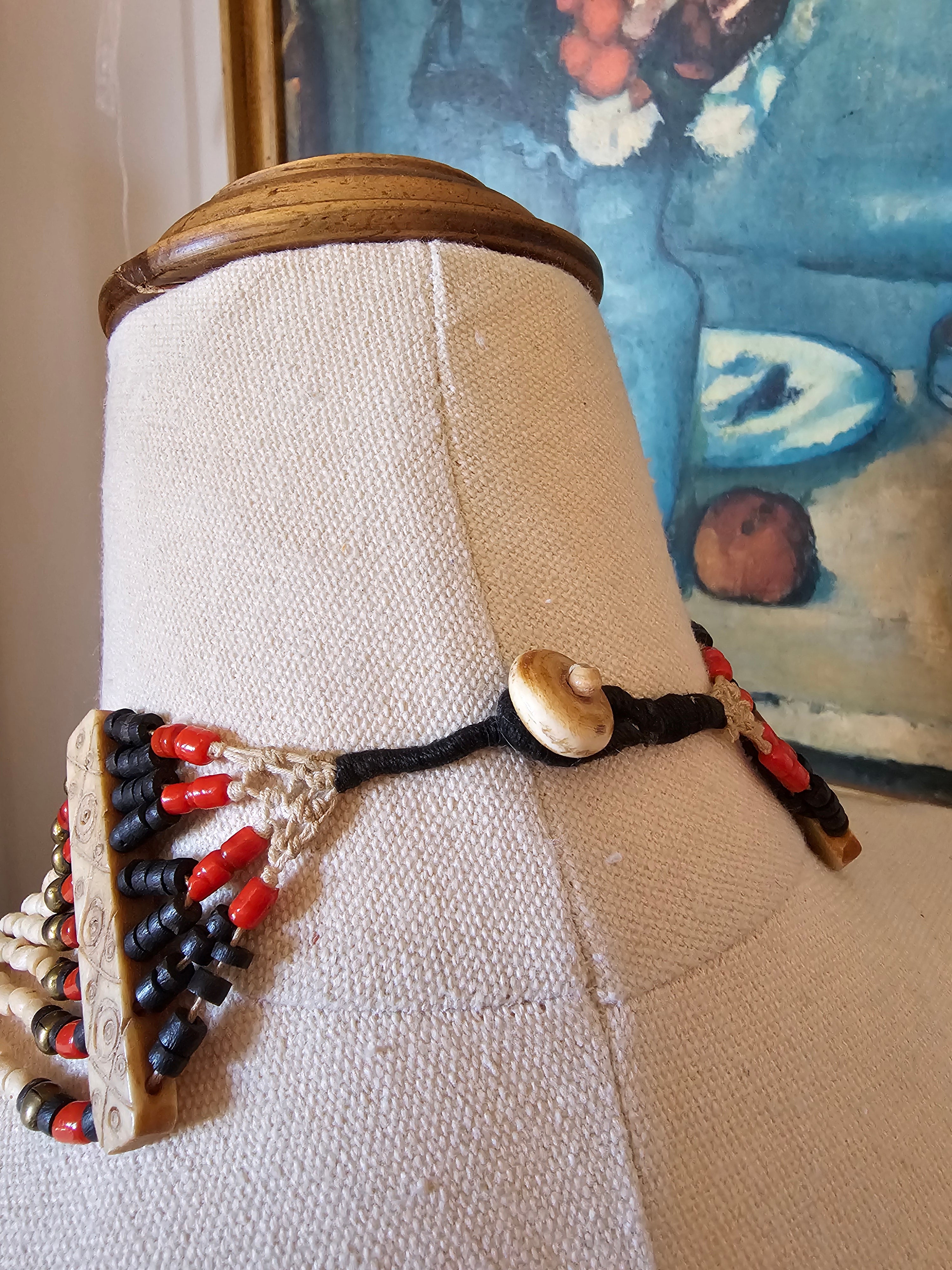 Decorative object with beads and a button on a textured surface