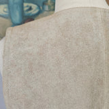 Close-up of a person wearing beige pants and white shoes with a blurred background