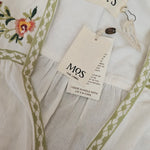 White fabric with green embroidery and floral design, featuring 'MOS' tags.