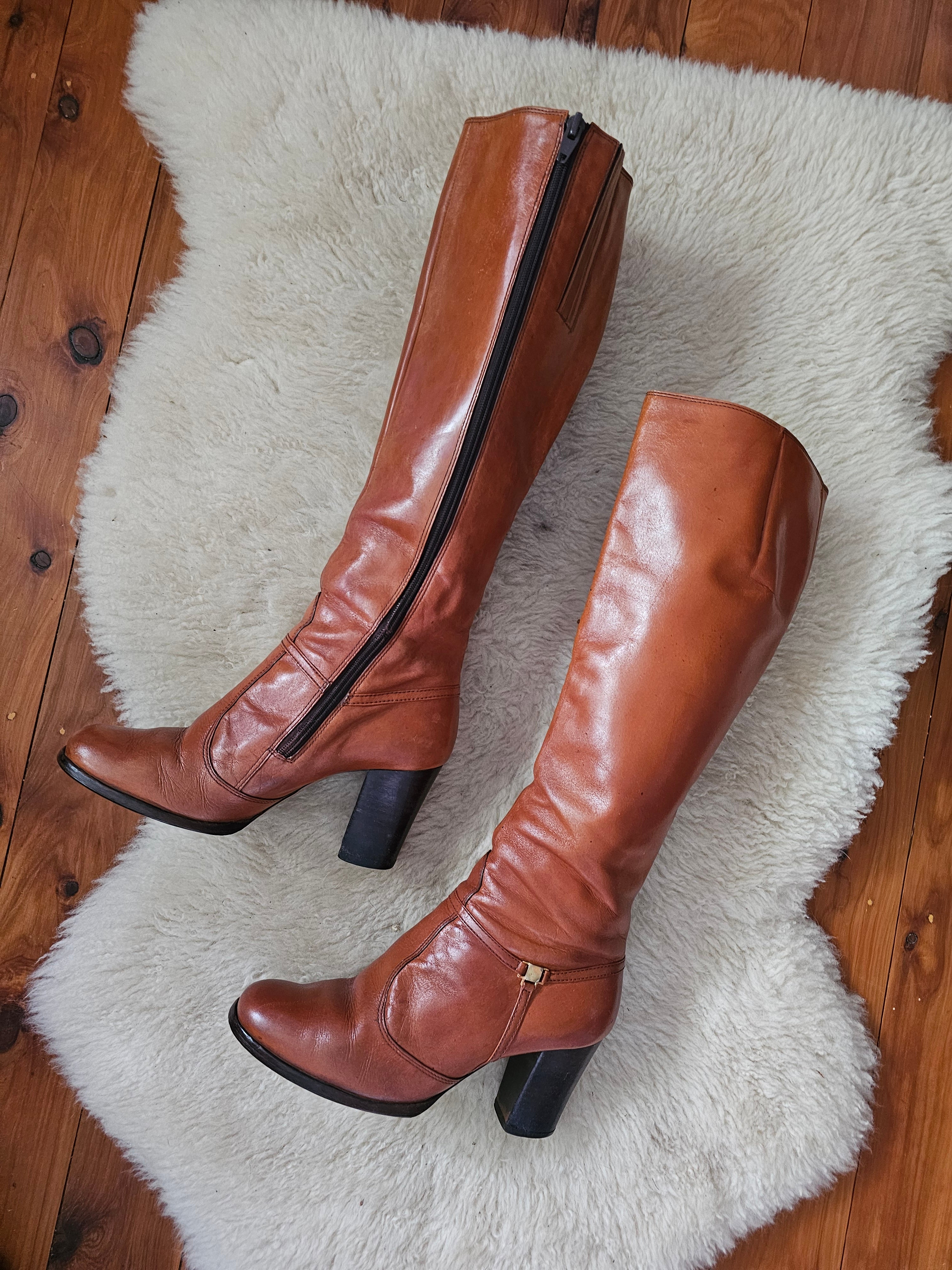 Brown knee-high boots on a white fur rug with wooden floor background