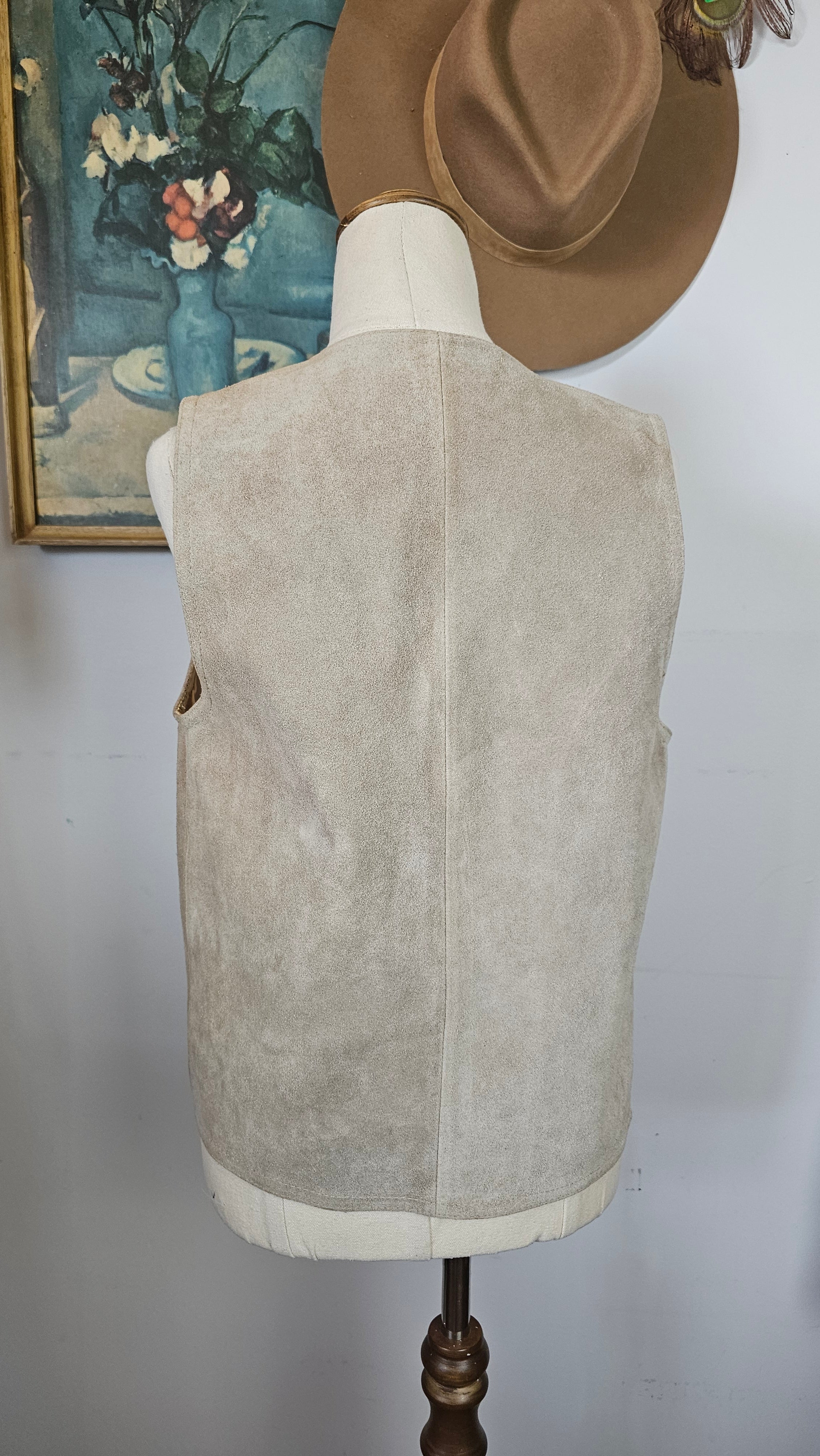 Mannequin wearing a beige dress with a brown hat on a white background