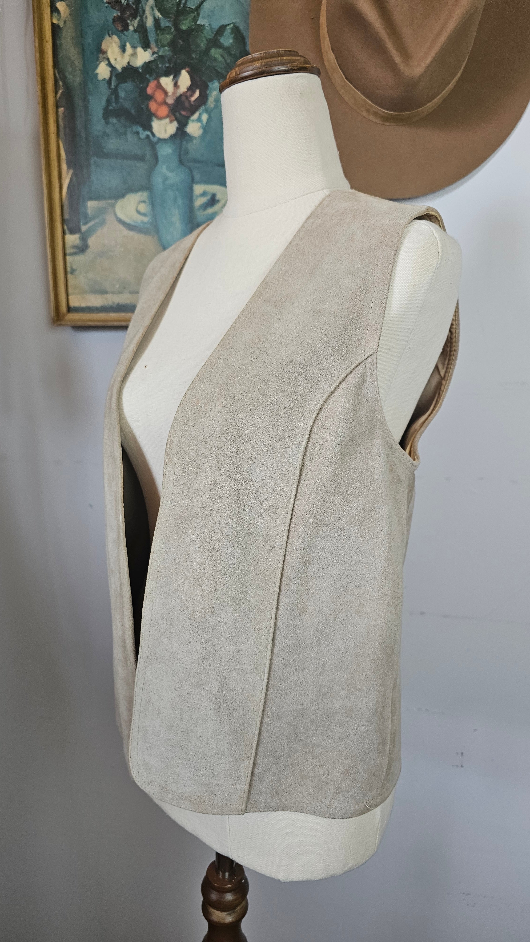 Mannequin wearing a beige coat with a plain background