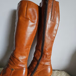 Brown leather boots on a light gray surface