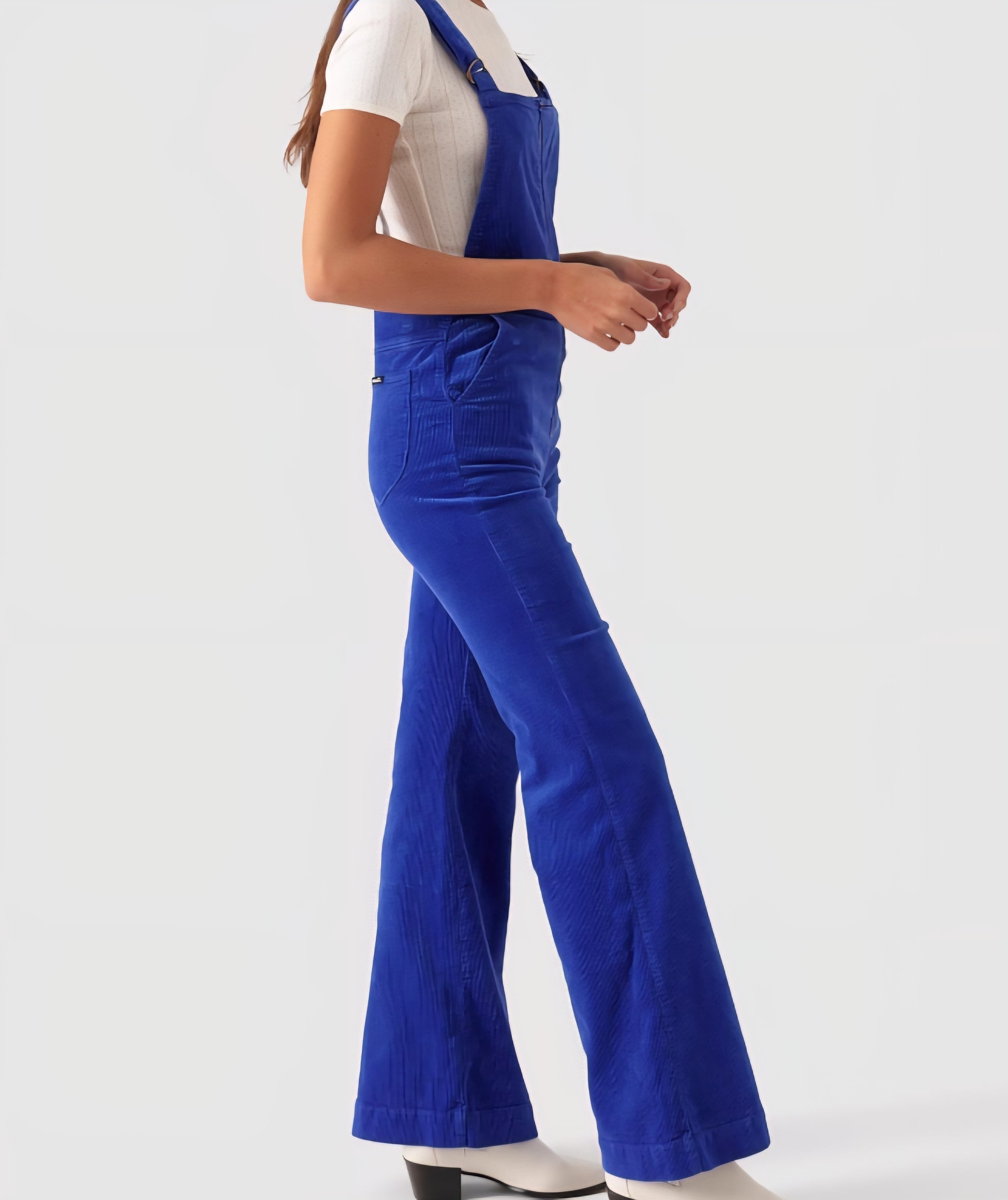 Person wearing blue overalls on a white background