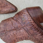 Close-up of a brown leather shoe with a textured sole on a light background