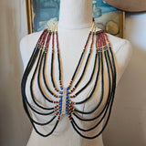 Set of necklaces displayed on a mannequin bust with a painting in the background