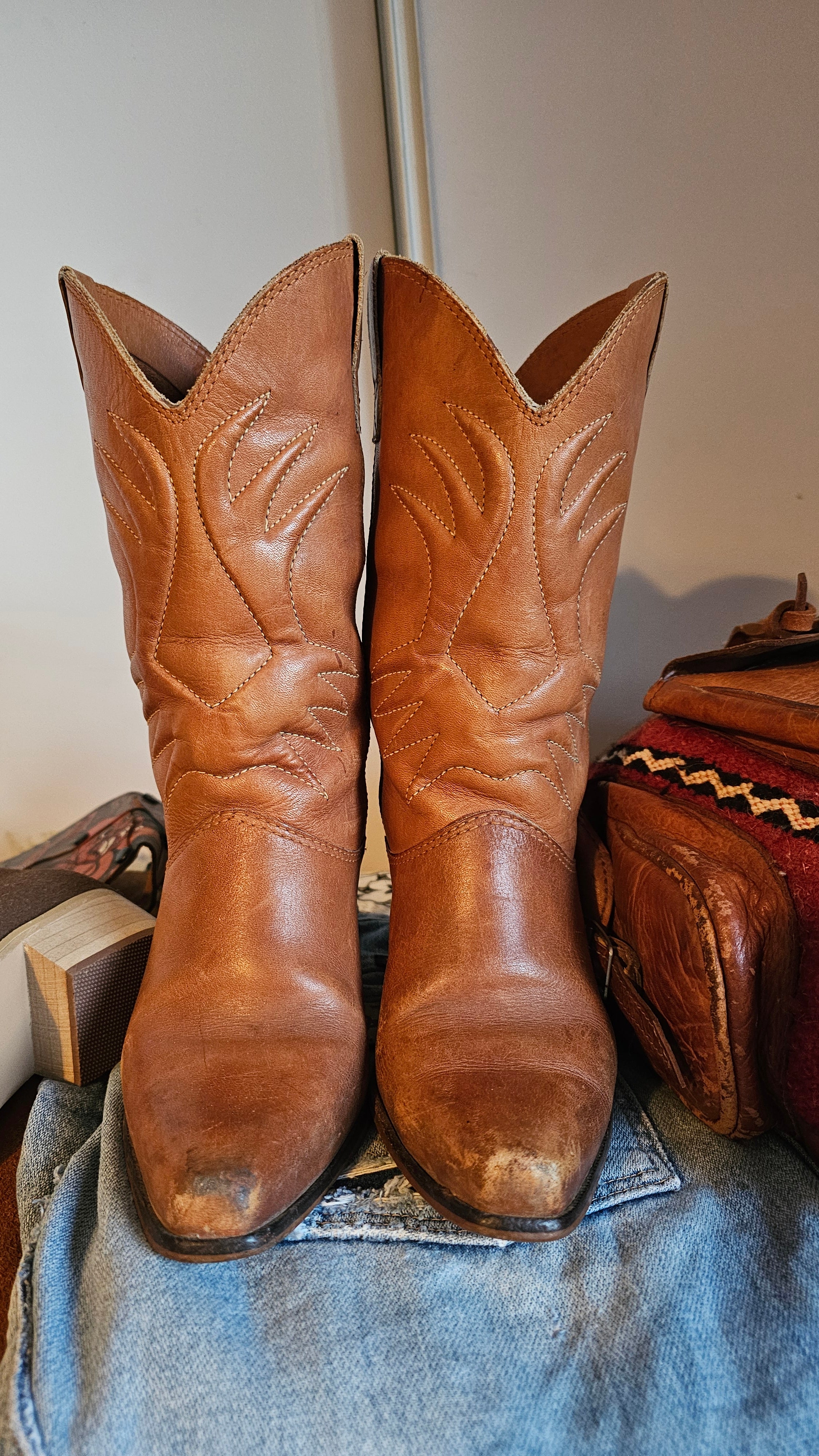 Vintage Brazilian Boots - Size 7B in tan leather with classic Western stitching, displayed front-facing on denim for a rustic 70s boots look.