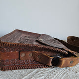 Brown leather bag with intricate designs on a textured surface