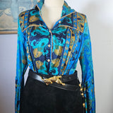Mannequin wearing a blue patterned jacket with gold accents on a white background