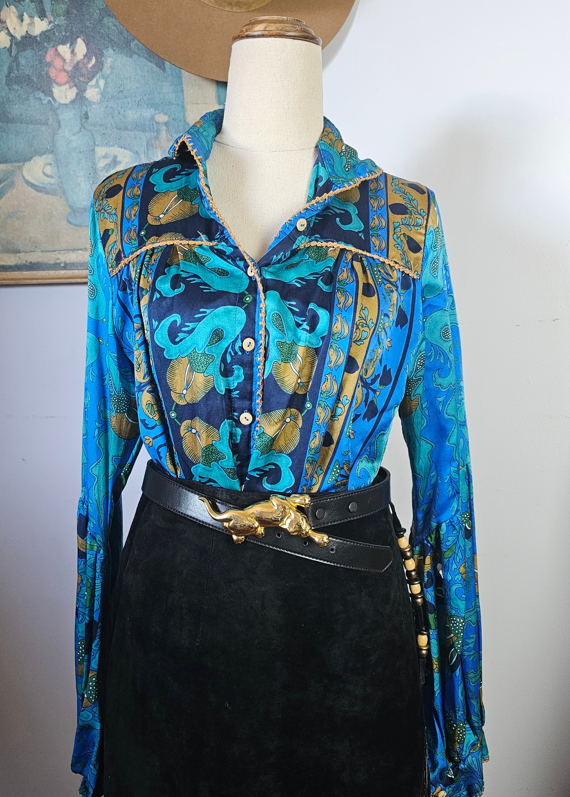 Mannequin wearing a blue patterned jacket with gold accents on a white background
