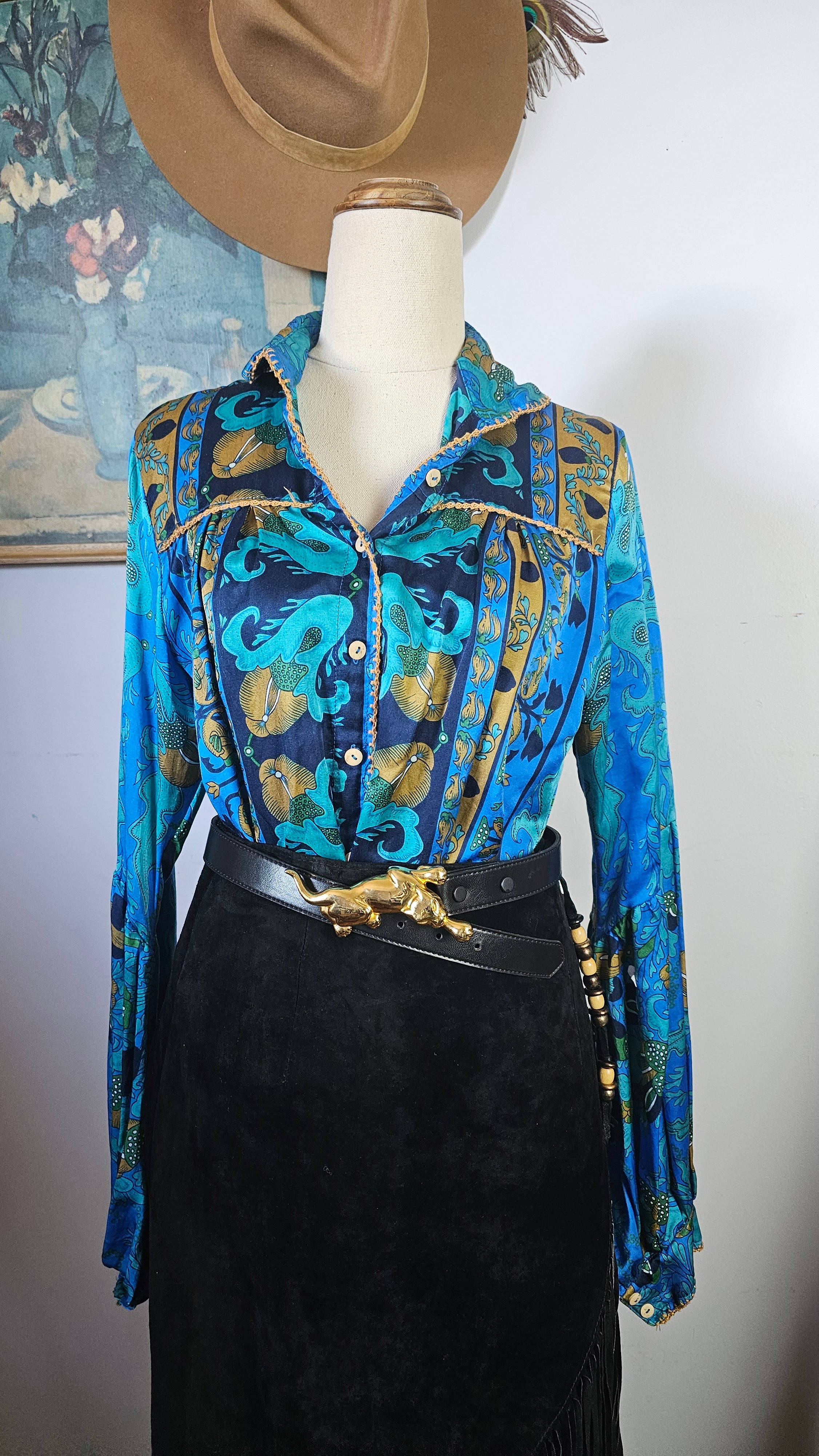 Mannequin wearing a blue patterned jacket with gold accents on a white background