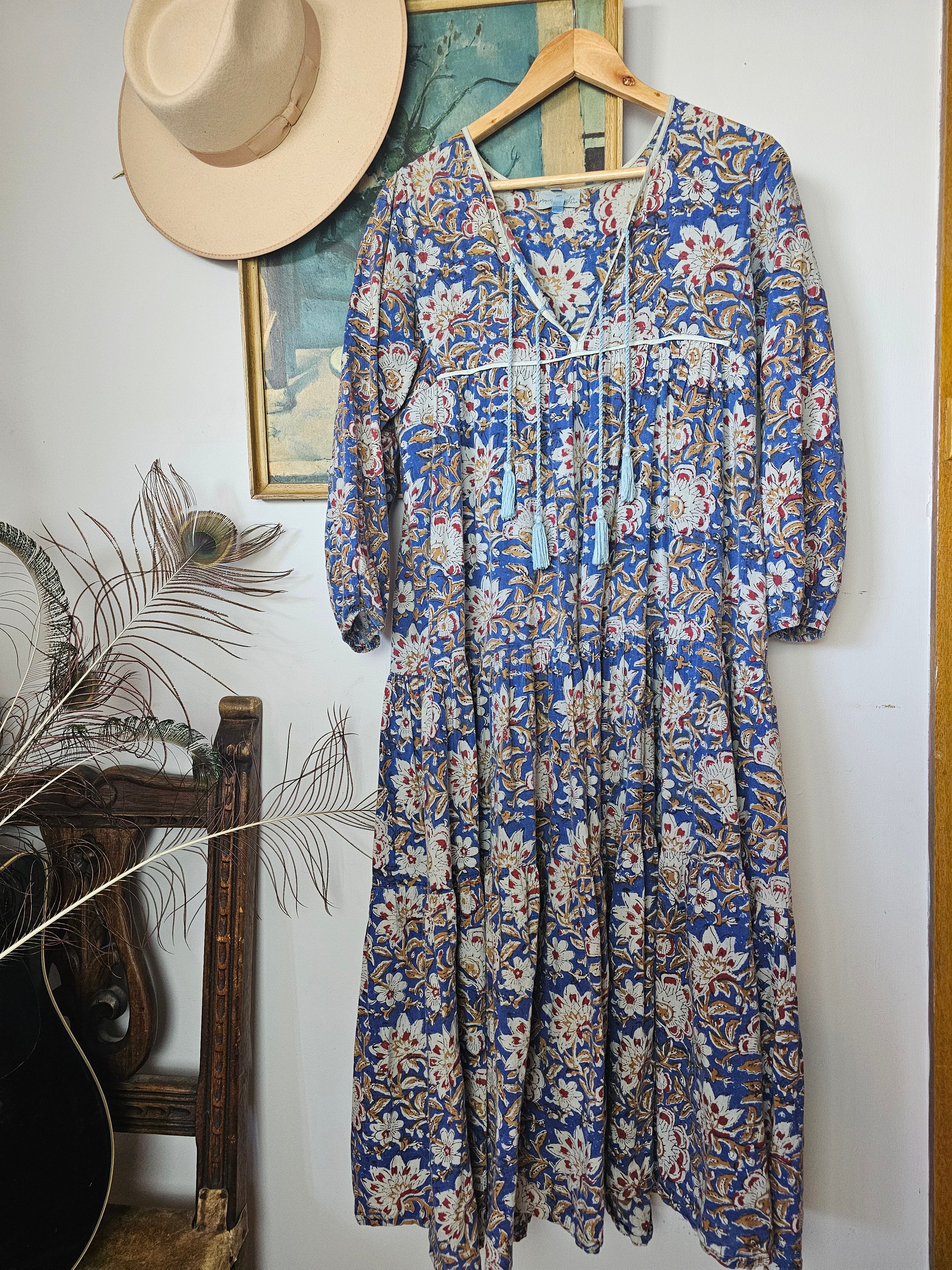 Property of Zephyr – Sienna Long Layer Dress hanging on wooden hanger, showing full length and intricate floral paisley design, size small.
