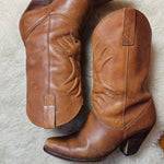 Vintage Brazilian Boots - Size 7B laid flat on a sheepskin rug, showcasing the curved heels and detailed stitching of these 70s leather boots.