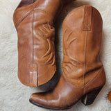 Vintage Brazilian Boots - Size 7B laid flat on a sheepskin rug, showcasing the curved heels and detailed stitching of these 70s leather boots.
