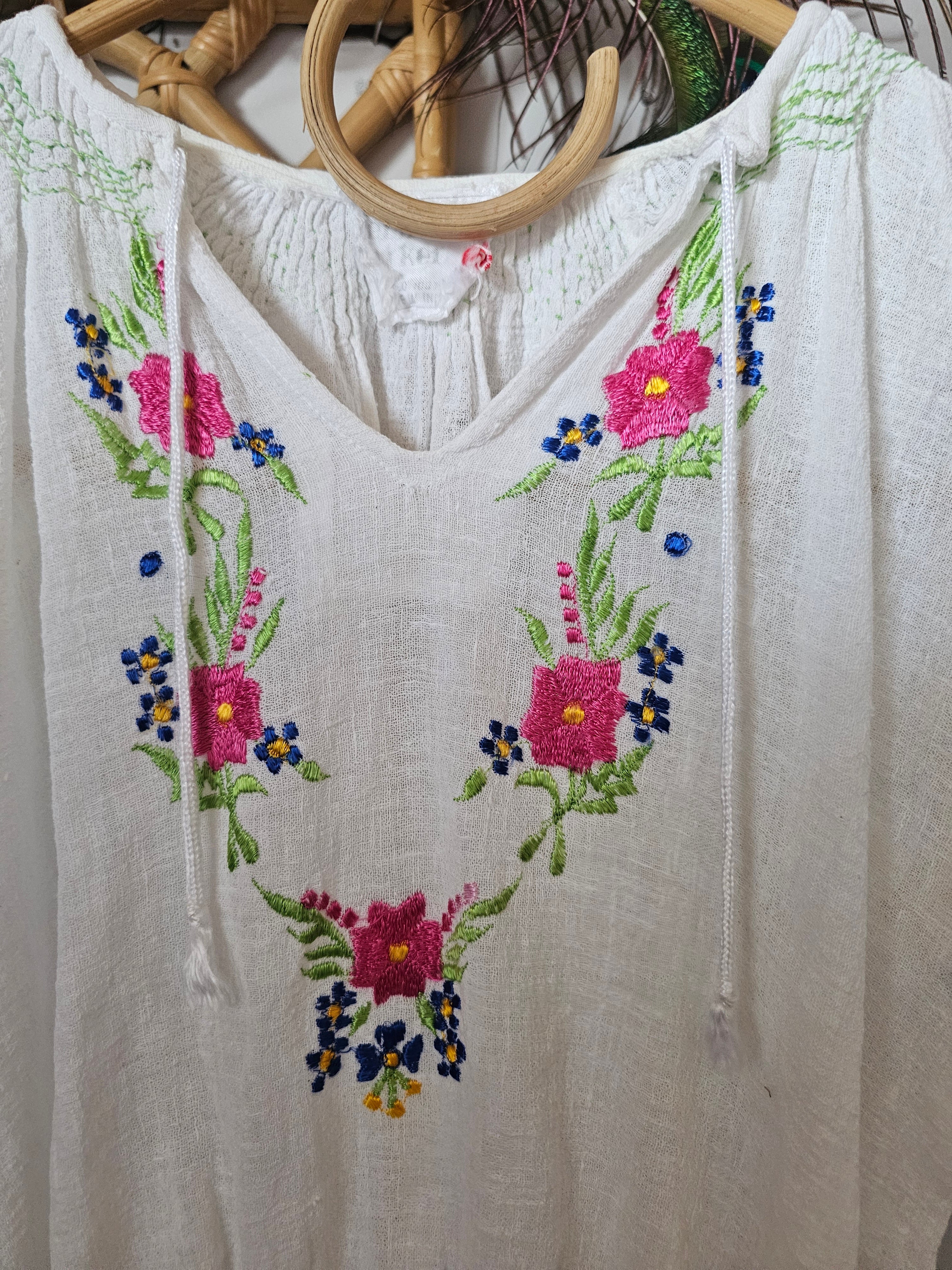 White fabric with floral embroidery on a wooden surface