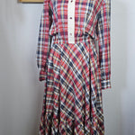 Plaid shirt on a mannequin against a white wall with decorative elements.