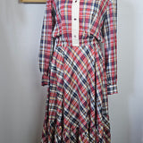 Plaid shirt on a mannequin against a white wall with decorative elements.