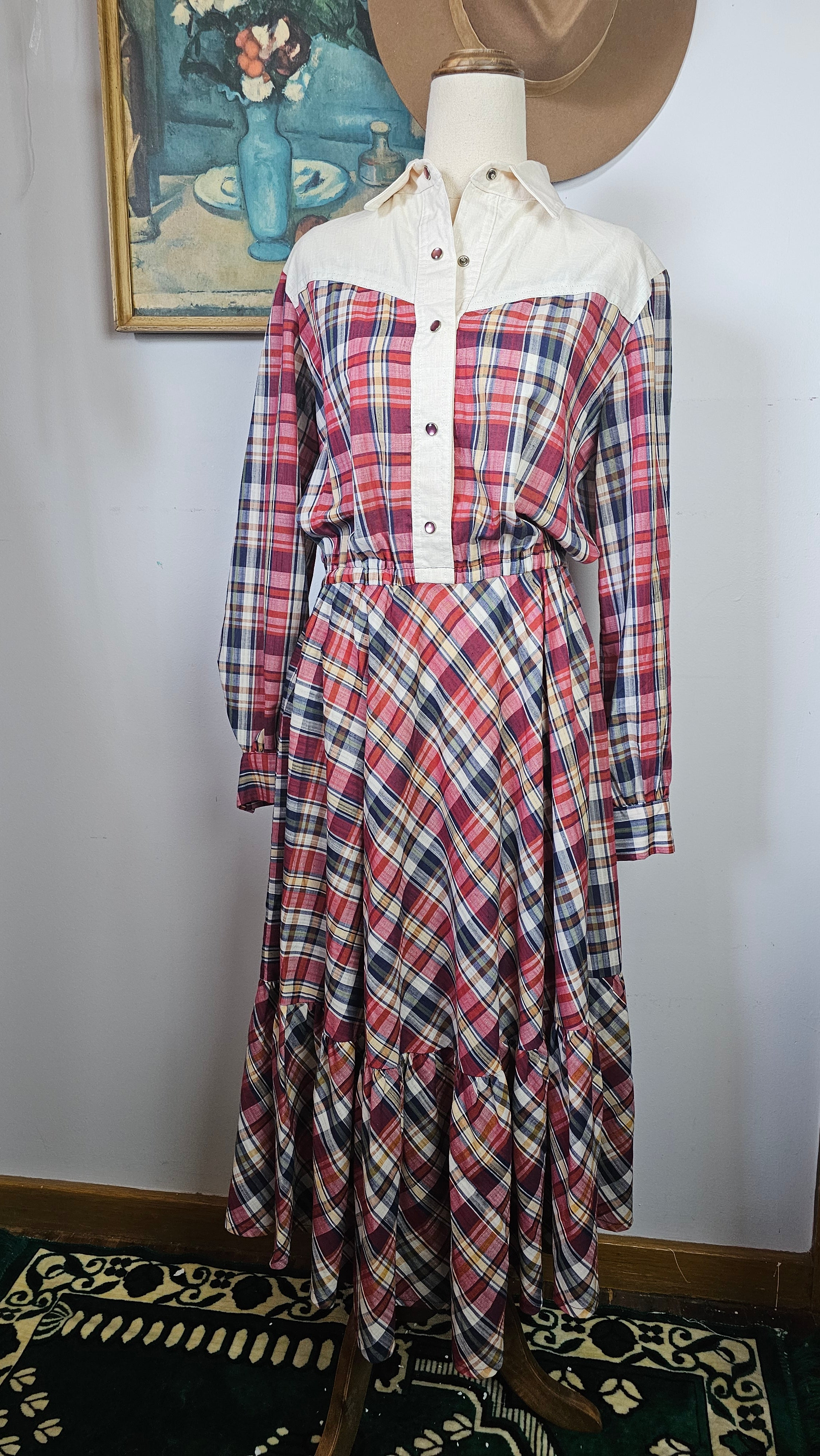 Plaid shirt on a mannequin against a white wall with decorative elements.