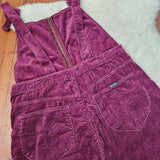 Purple corduroy dress on a wooden floor with a white rug underneath