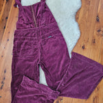 Purple corduroy pants on a wooden floor with a white rug underneath