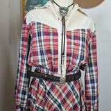 Plaid shirt with white jacket and brown hat on a surface