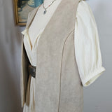 Mannequin wearing a beige suit with a white shirt and brown hat on a plain background