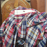 Plaid shirt on a wooden surface with a blurred background