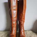 Pair of brown leather knee-high boots on a light background