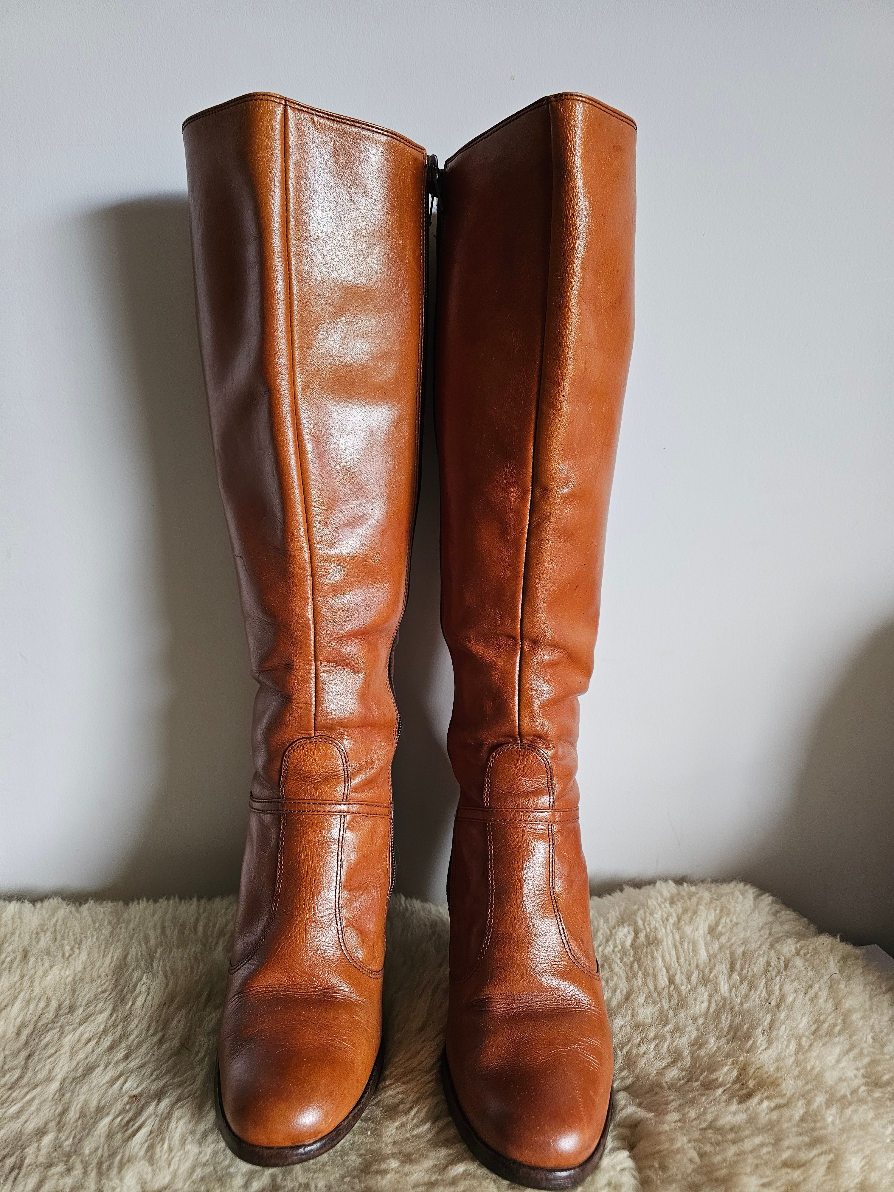 Pair of brown leather knee-high boots on a light background