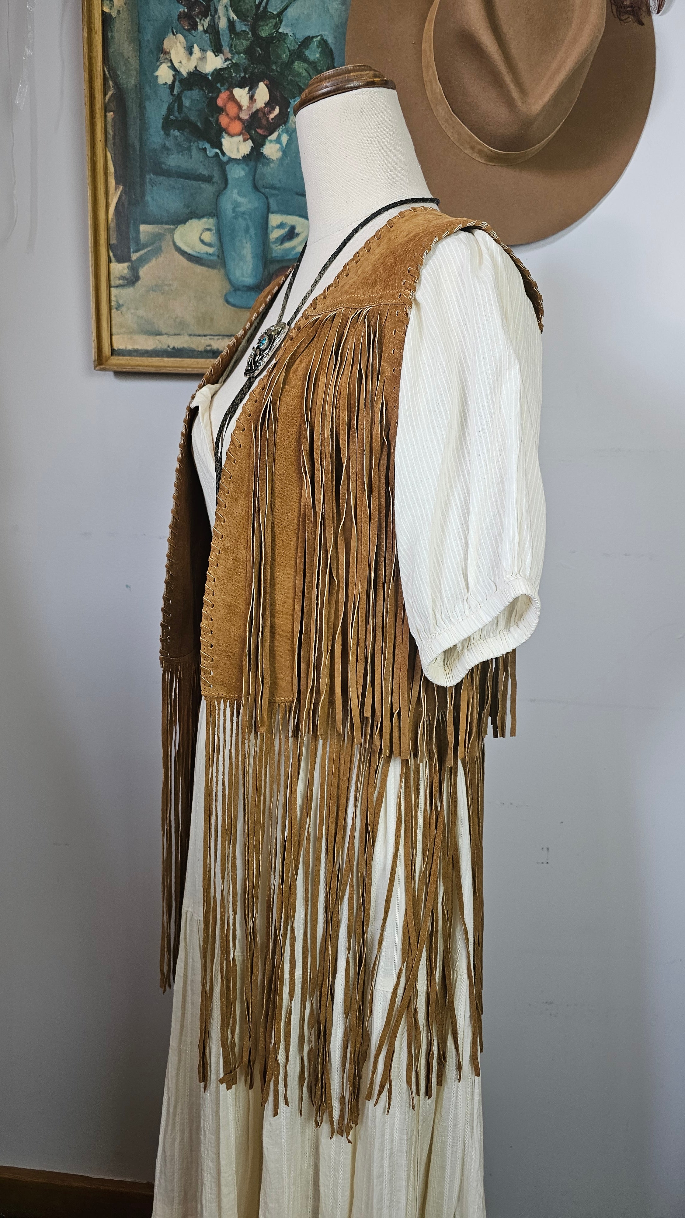 Mannequin wearing a vintage-style dress with a large fan on a plain background