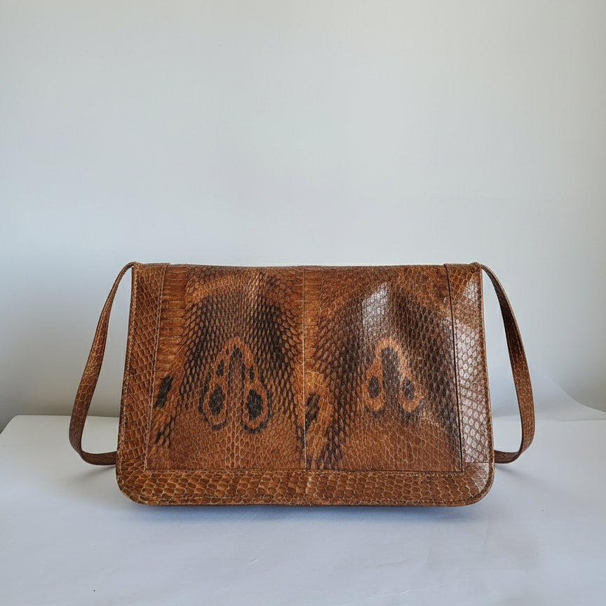 Brown leather wallet with snake skin pattern on a white background