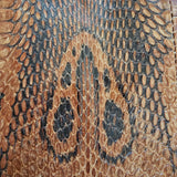 Close-up of a snake skin pattern with brown and black colors.