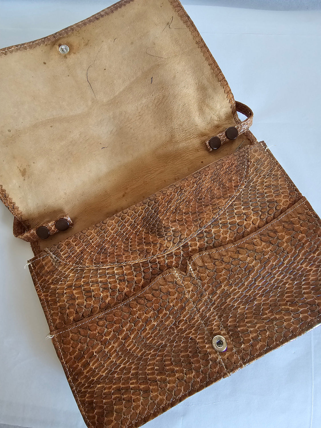 Brown leather-bound book with visible wear on a white background