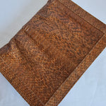 Brown textured leather clutch bag on a light gray background